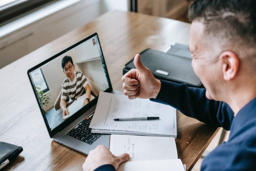 A man giving a thumbs up to someone on a video call