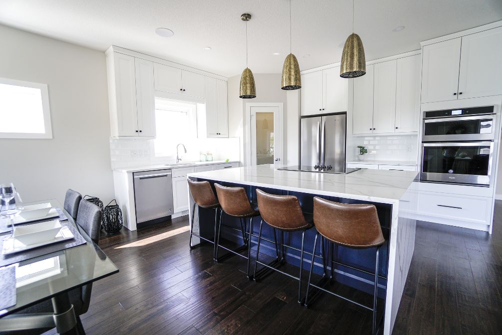 Kitchen with four lather bar stools and work island